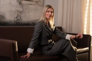 Retrato horizontal de mujer rubia en traje posando sobre sofá marrón – Palma de Mallorca