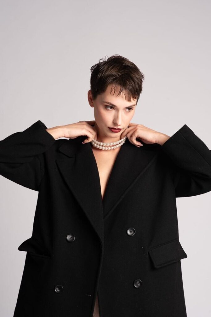 Modelo posando con abrigo negro en sesión de fotografía editorial y moda en Mallorca