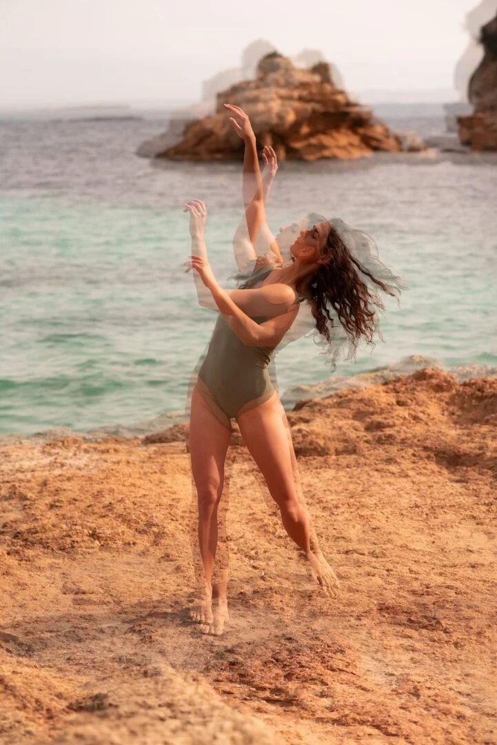 Bailarina saltando sobre la arena de una cala de Mallorca