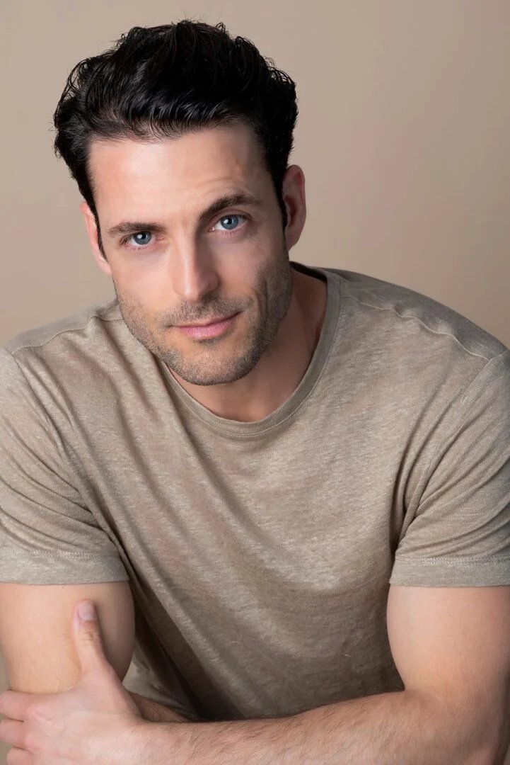 Headshot de actor con camiseta beige sobre fondo neutro